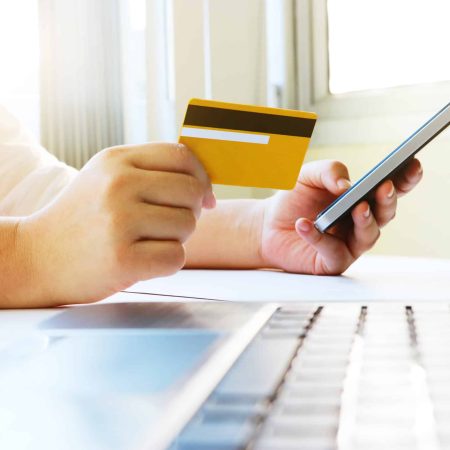 une personne effectue un paiement en ligne avec sa carte bancaire